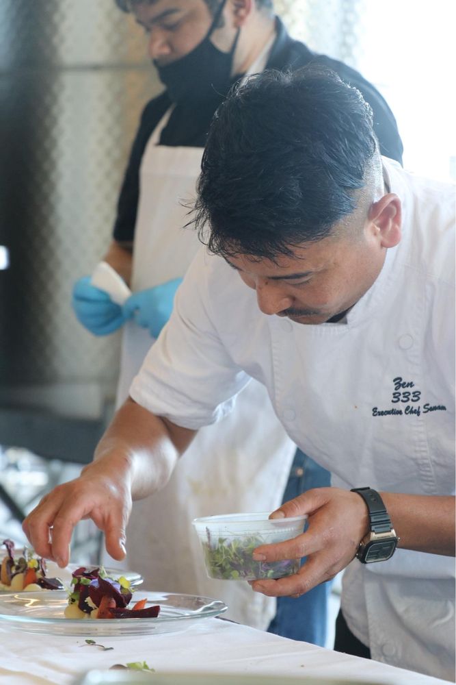Chef Sonam Sherpa garnishing a plate with micro greens